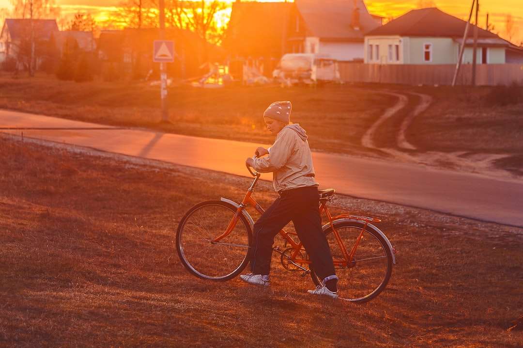 mężczyzna w białej kurtce jadący na rowerze podczas zachodu słońca puzzle online