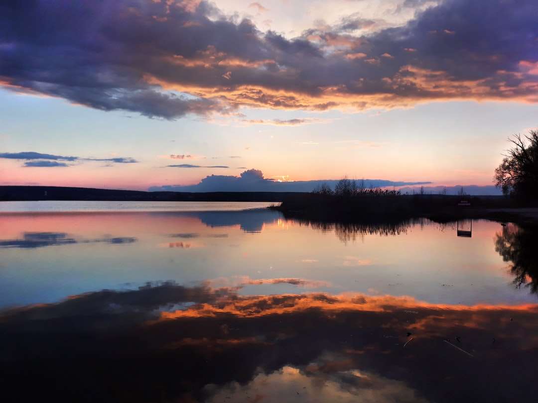 Ciało wody pod zachmurzonym niebem podczas zachodu słońca puzzle online