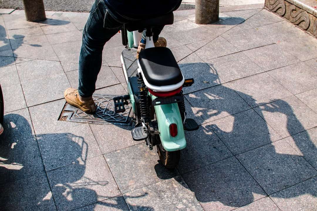 Osoba w czarnej kurtce jazda na białym i zielona skuter silnikowy puzzle online