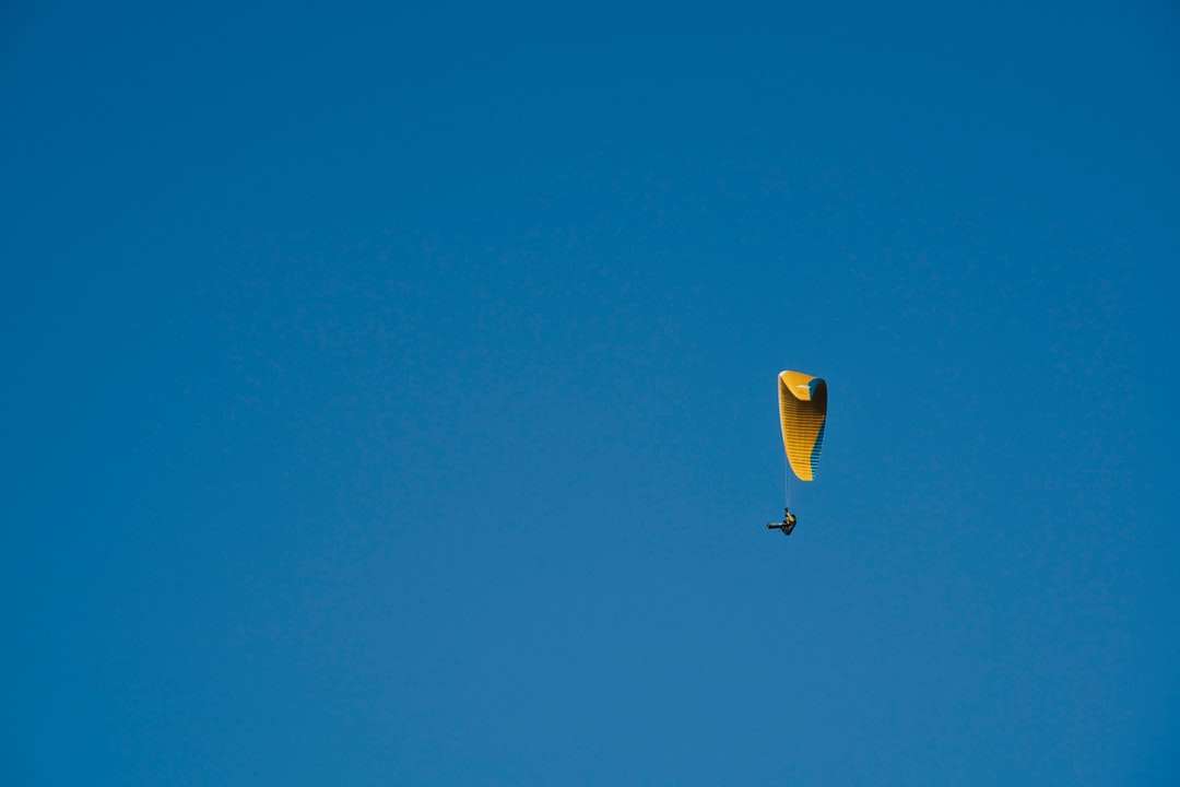 Żółty i zielony gorący powietrze balon w powietrzu pod błękitnym niebem puzzle online