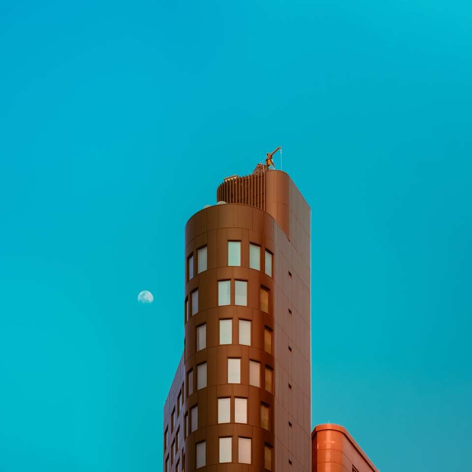 Brązowy betonowy budynek pod błękitnym niebem w ciągu dnia puzzle online