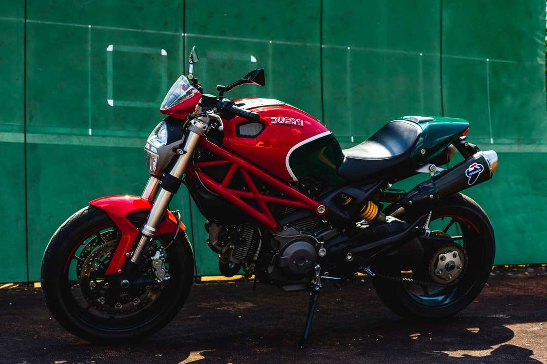 Czerwony i czarny rower sportowy zaparkowany obok zielonej ściany puzzle online