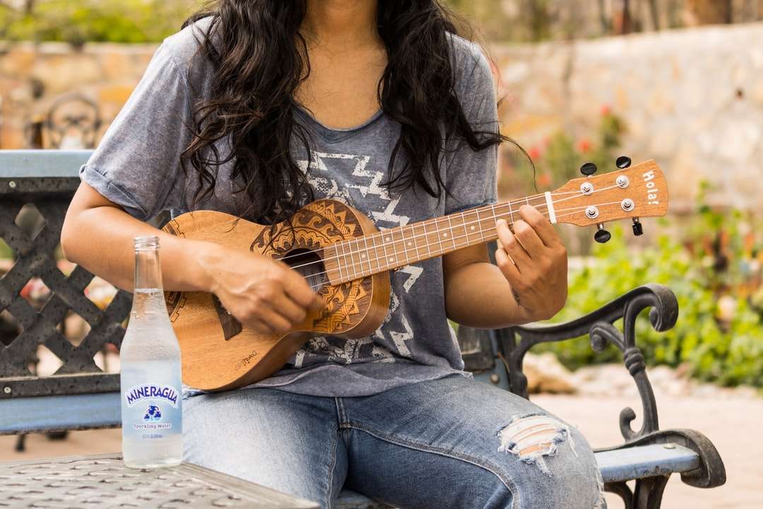 Kobieta w brązowej koszuli z długim rękawem gra gitara akustyczna puzzle online