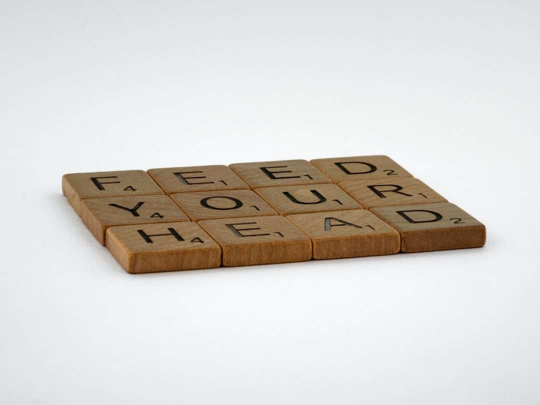 brązowe drewniane klocki z literami na białej powierzchni puzzle online