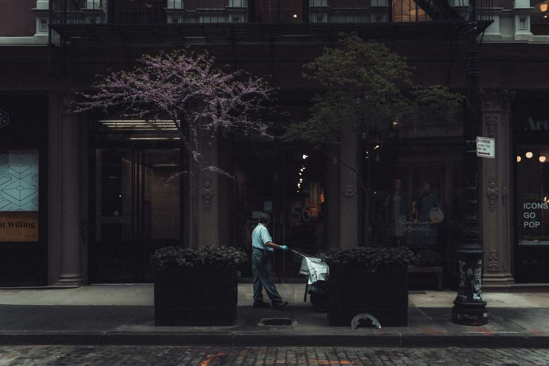 mężczyzna w niebieskiej kurtce i czarnych spodniach spacerujący po chodniku puzzle online