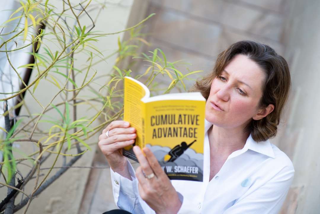 Kobieta w białym guzika w górę koszuli trzyma żółtą książkę puzzle online