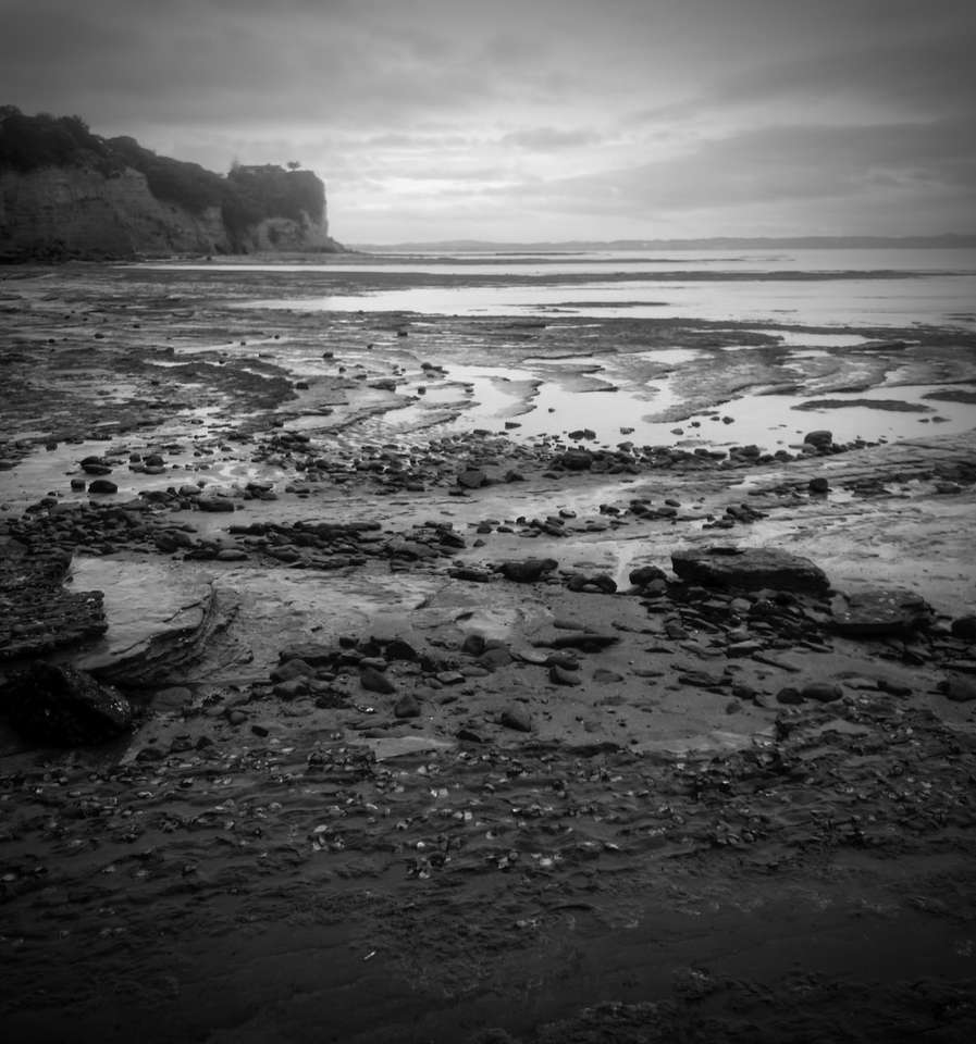Foto de cinza de ondas do mar batendo em rochas quebra-cabeça