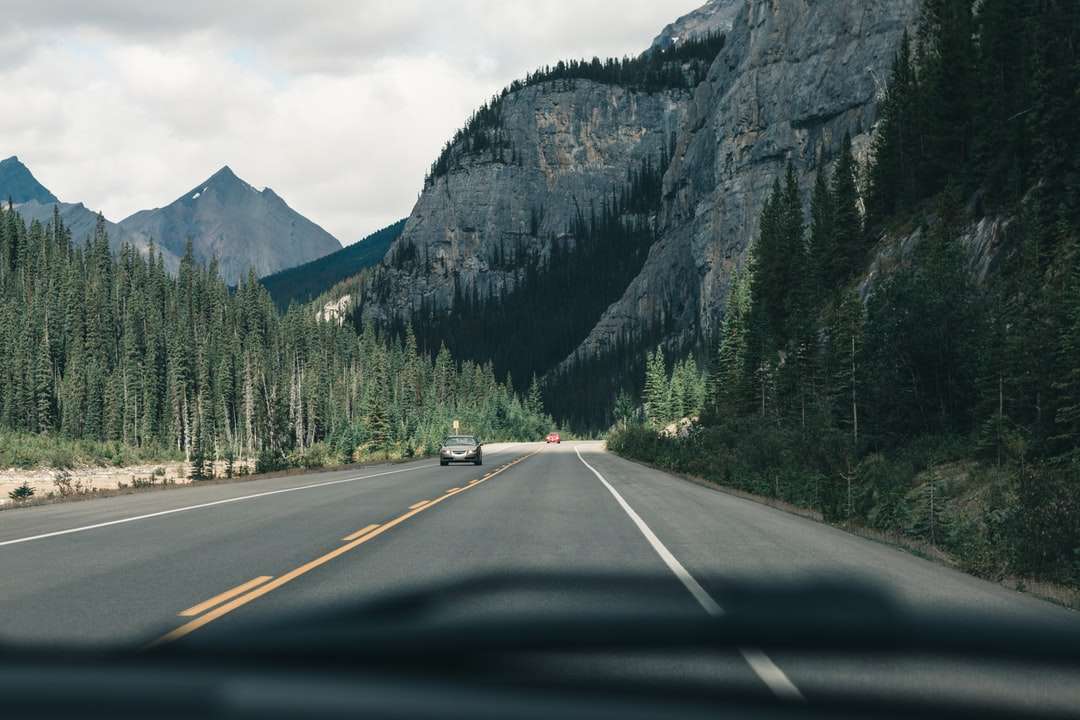 Szary samochód na drodze w pobliżu góry w ciągu dnia puzzle online