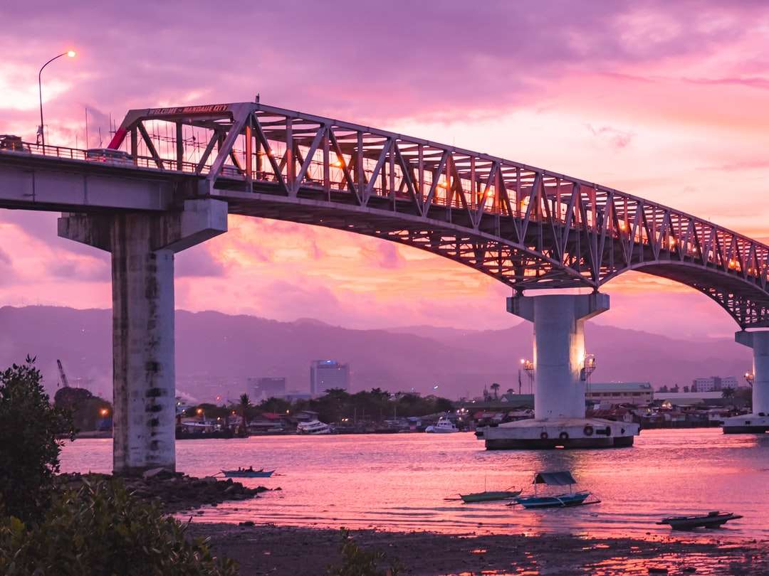 Biały betonowy most nad rzeką pod chmurnym niebem puzzle online