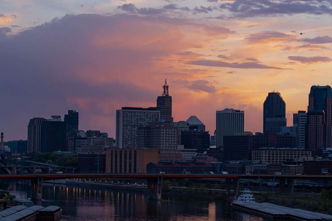 Skyline miasta podczas zachodu słońca z mostem puzzle online