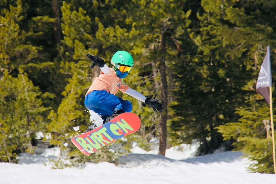 Mężczyzna w niebieskiej kurtce i czerwonym kasku jazda na czerwonym snowboardzie puzzle online