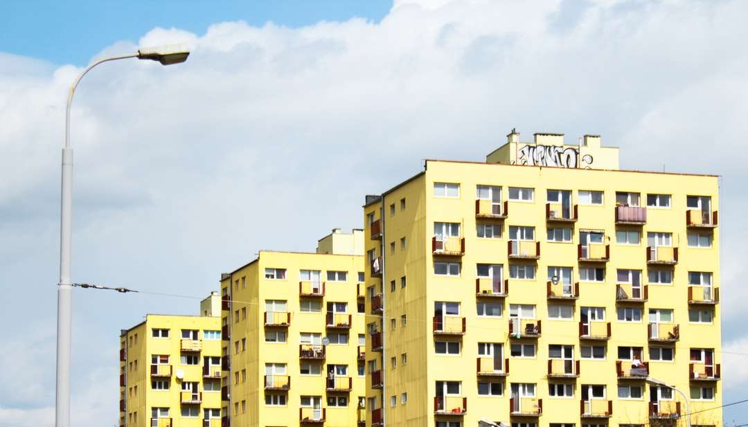 Żółty i brązowy budynek betonowy pod błękitnym niebem puzzle online