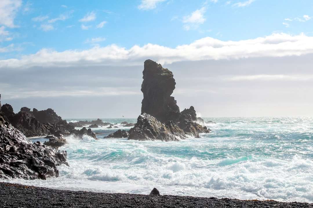 brązowa formacja skalna na morzu pod błękitnym niebem w ciągu dnia puzzle online