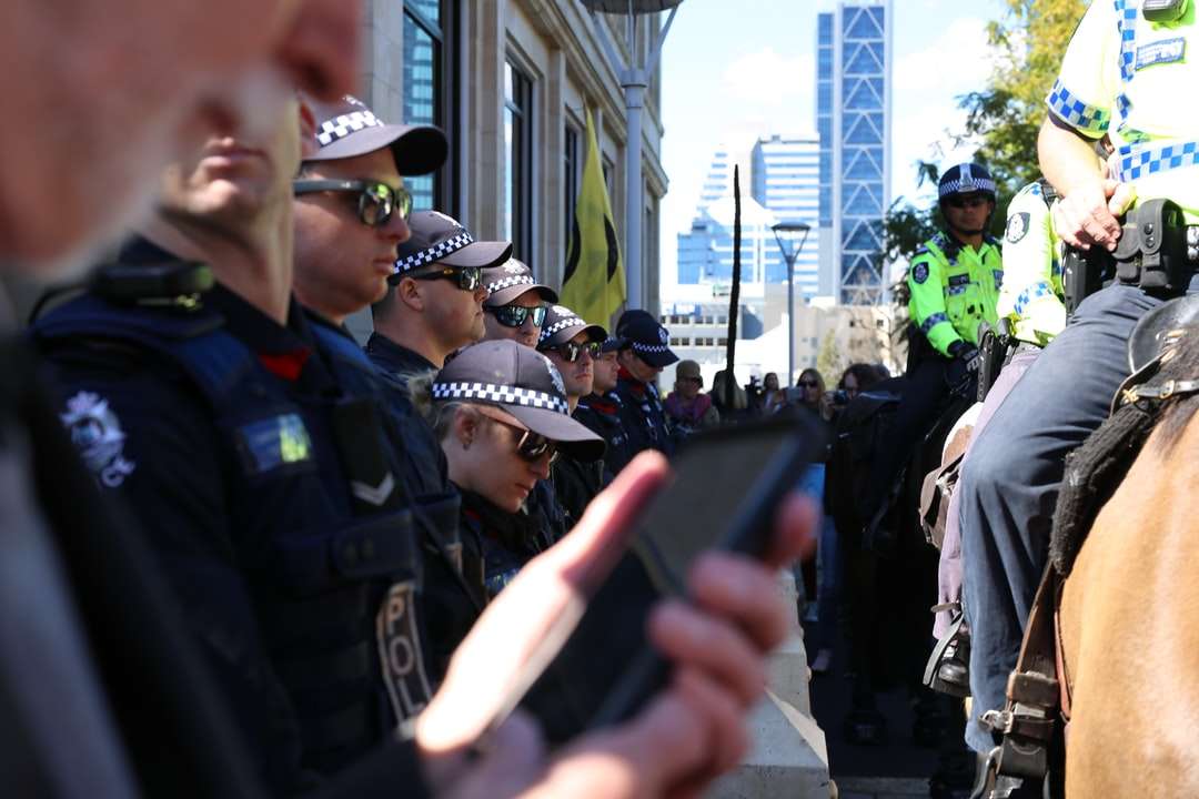 mężczyzna w czarnym mundurze policyjnym trzymający czarny smartfon puzzle online