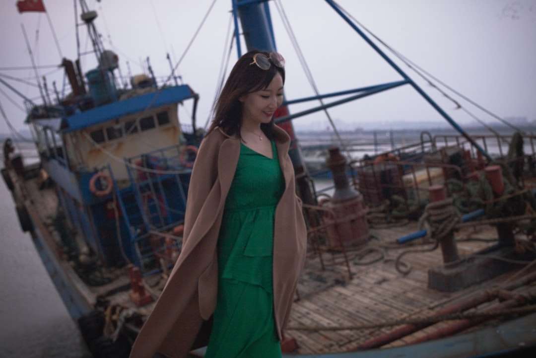 Kobieta w zielonej sukni bez rękawów stoi na brown piasku puzzle online