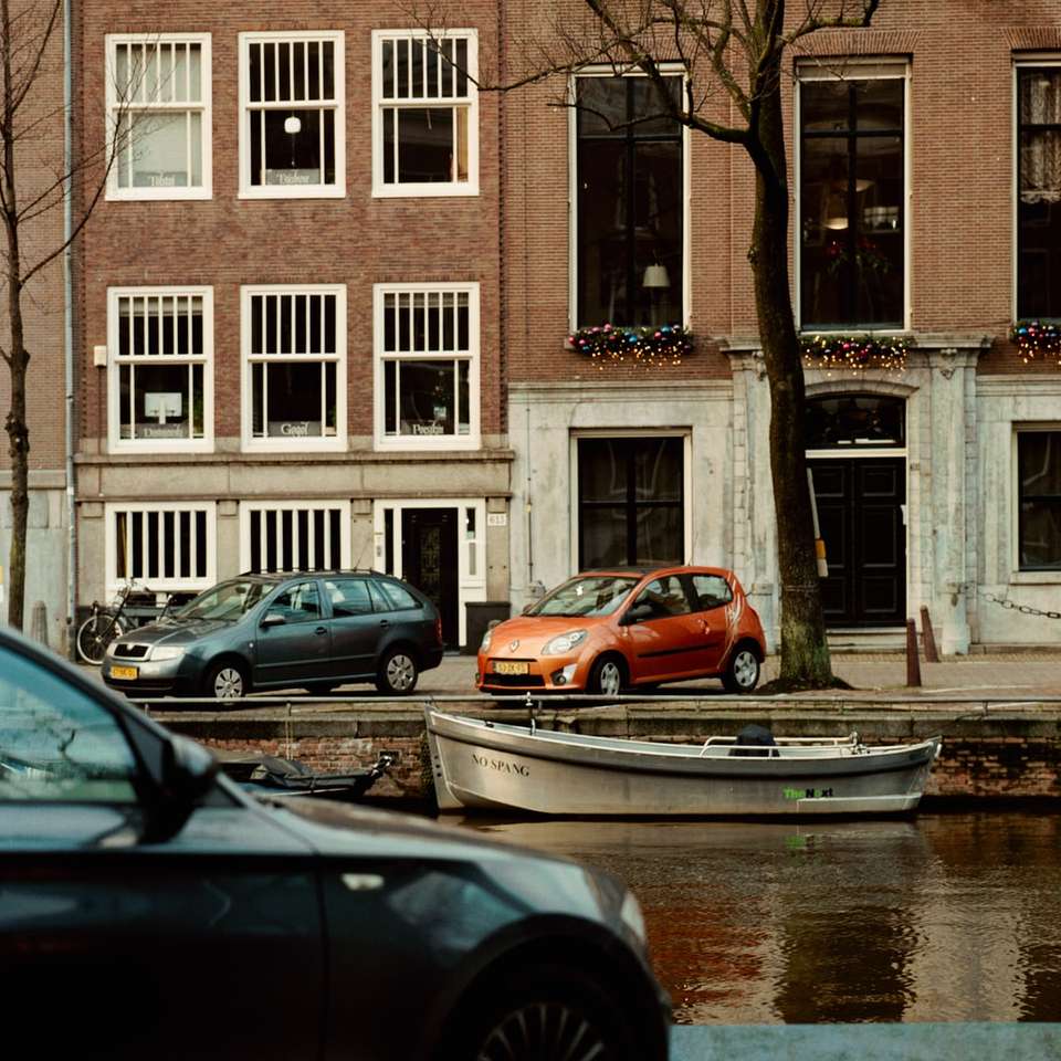 Samochody zaparkowane przed brązowym i białym budynkiem puzzle online