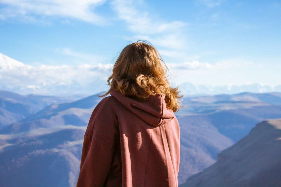Kobieta w brown kapturem stoi na górze góry puzzle online