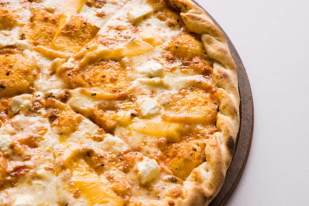 Pizza na brązowej drewnianej tacy puzzle online