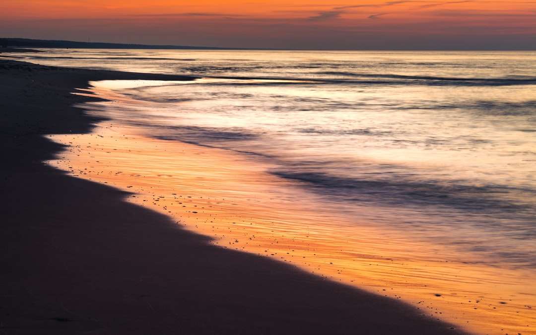 Fale oceanu rozbijające się na brzegu podczas zachodu słońca puzzle online