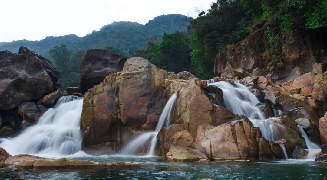 Wodospady między brązową górską górą w ciągu dnia puzzle online