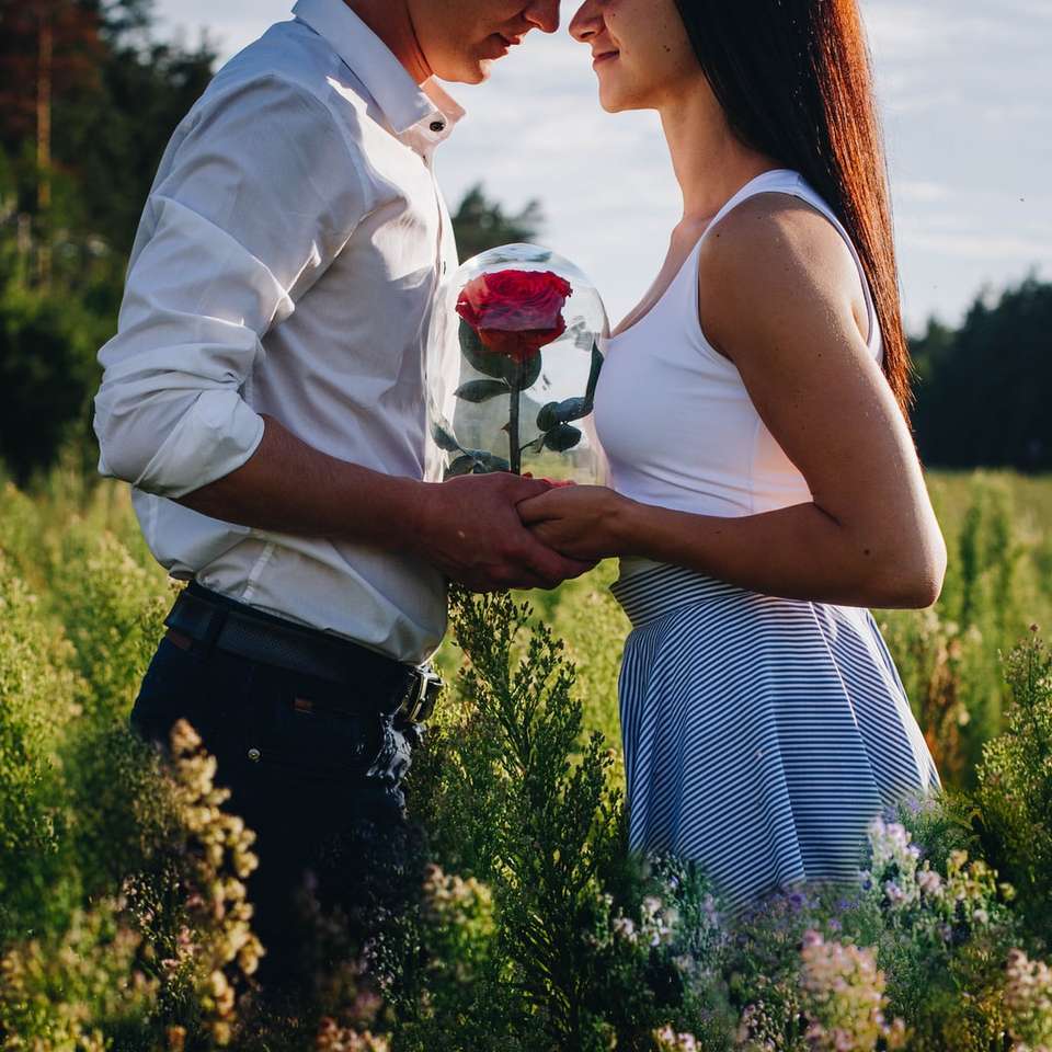 Mężczyzna w białej sukni koszula mienia czerwieni róża puzzle online