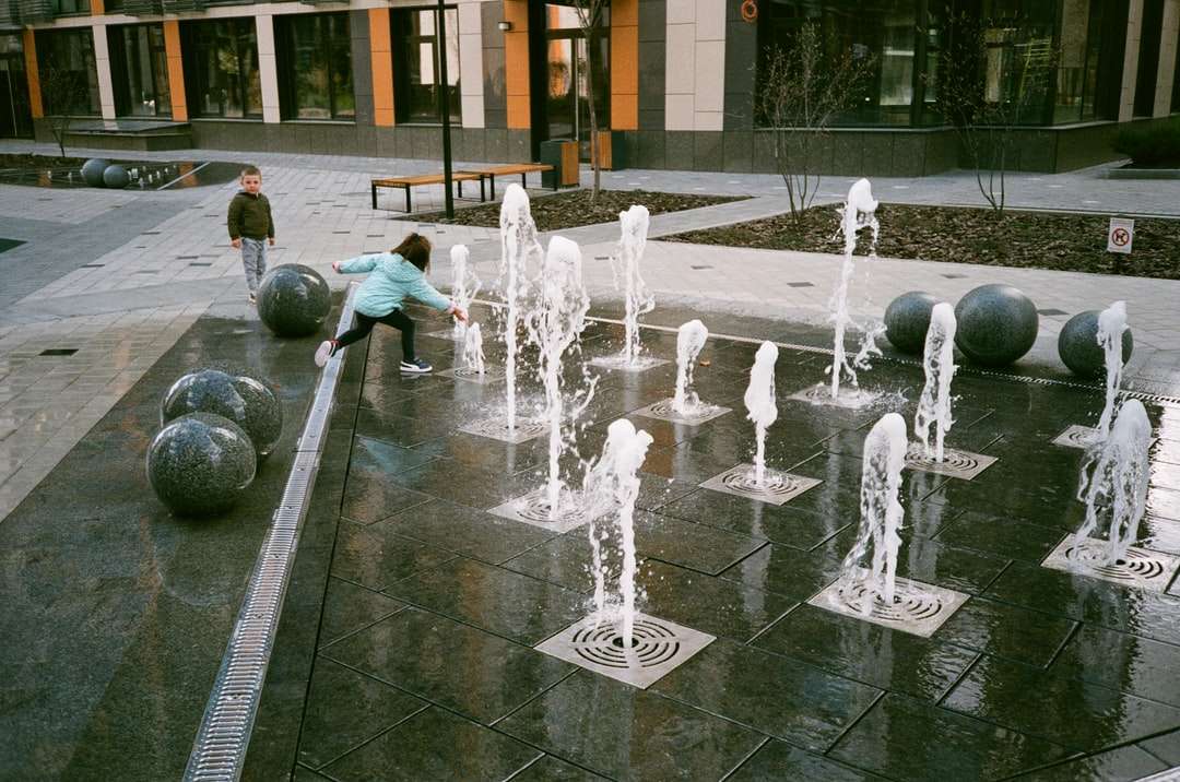 Ludzie bawiący się na fontannie wody w ciągu dnia puzzle online