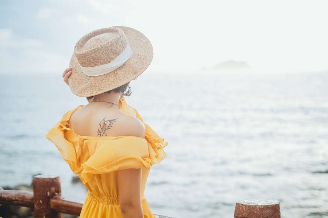 Kobieta w żółtej sukni jest ubranym białego słońca kapelusz puzzle online