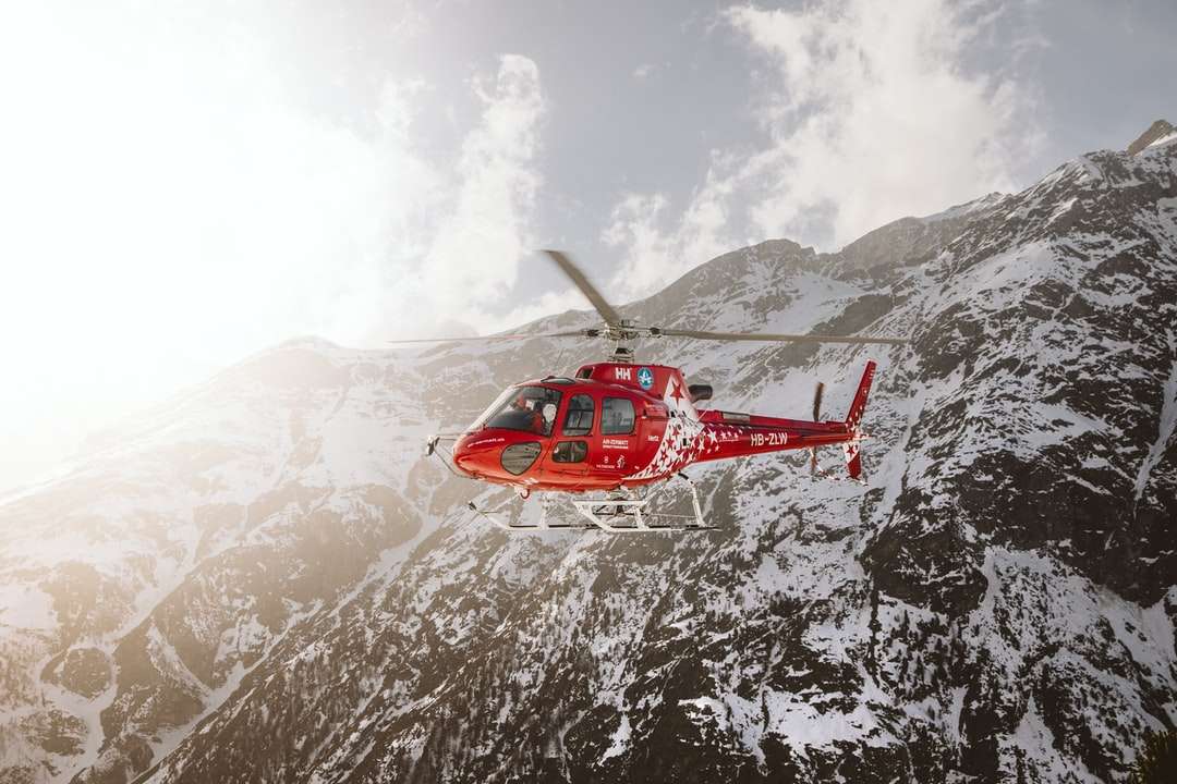 Czerwony i biały helikopter latający nad śniegiem pokryte górą puzzle online