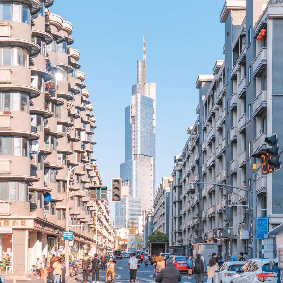 Ludzie chodzą po ulicy w pobliżu wysokich budynków puzzle online