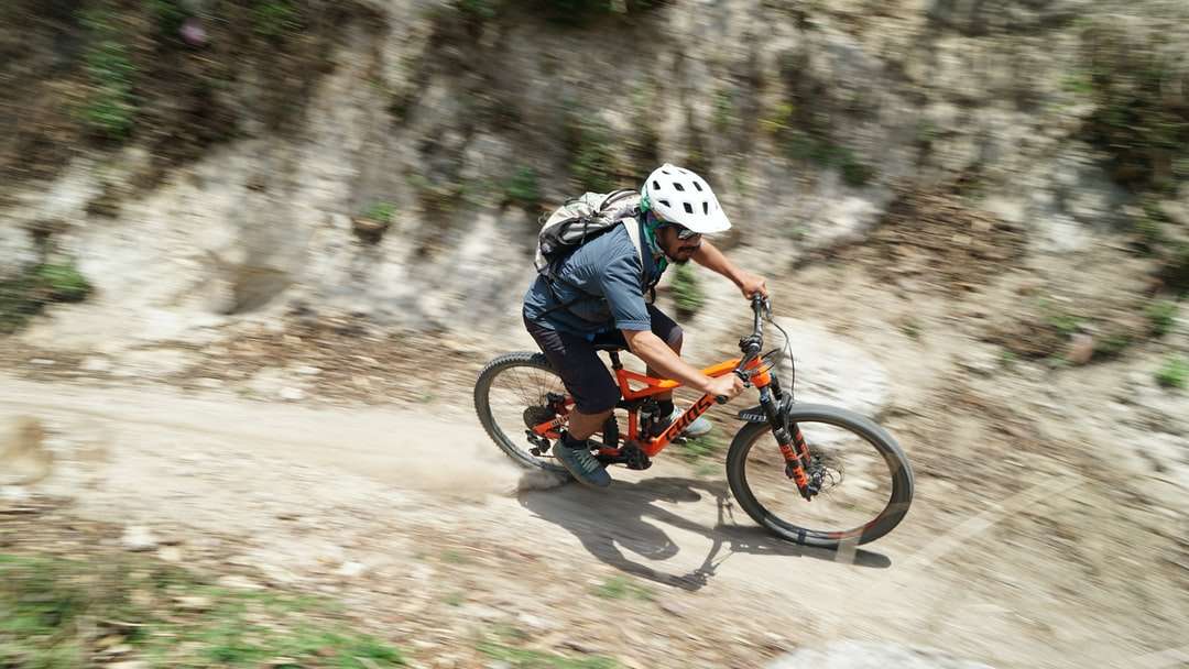 Mężczyzna w niebieskiej kurtce jazda na rowerze pomarańczowym bmx puzzle online