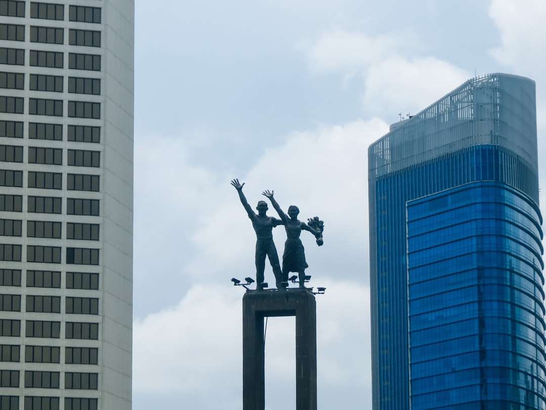 Czarna statua człowieka na szczycie budynku puzzle online