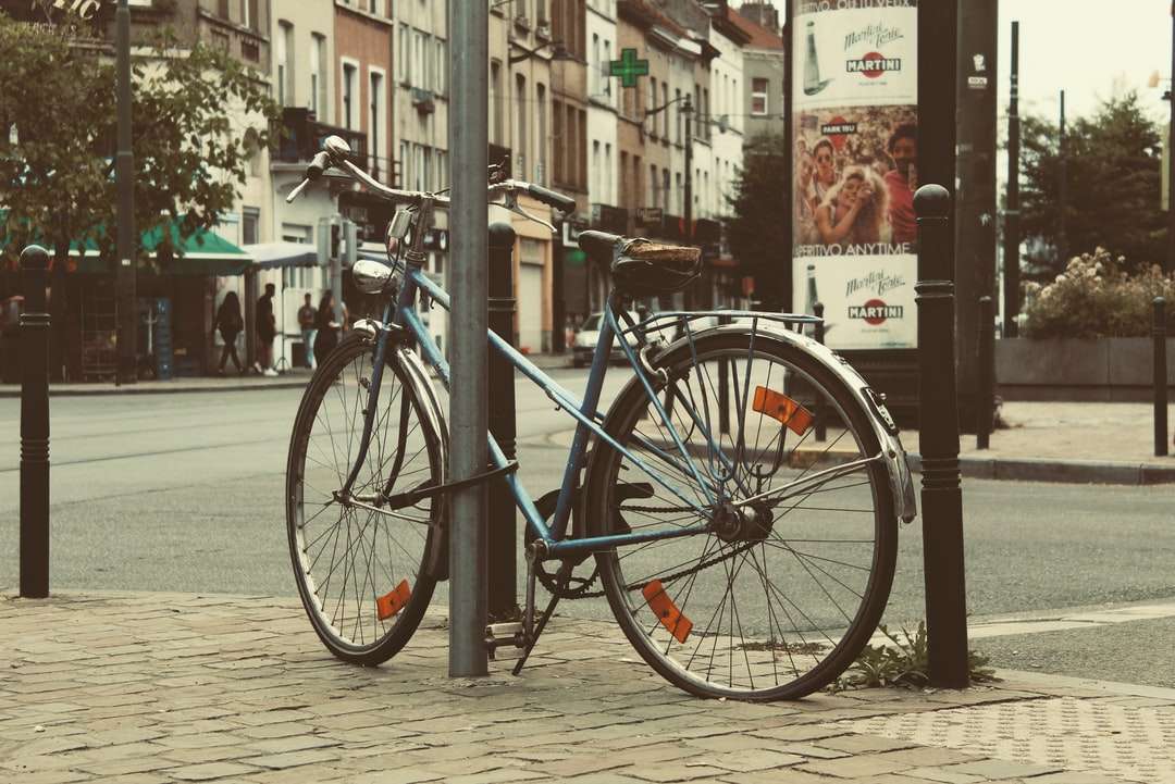 Błękitny miasto rower zaparkowany obok czarnego metalowego ogrodzenia puzzle online