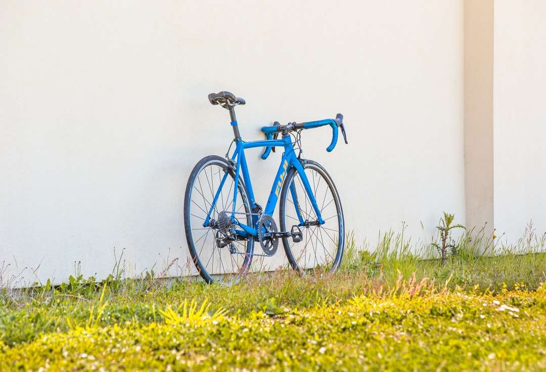 Niebieski i czarny rower drogowy na żółtym polu kwiatu puzzle online