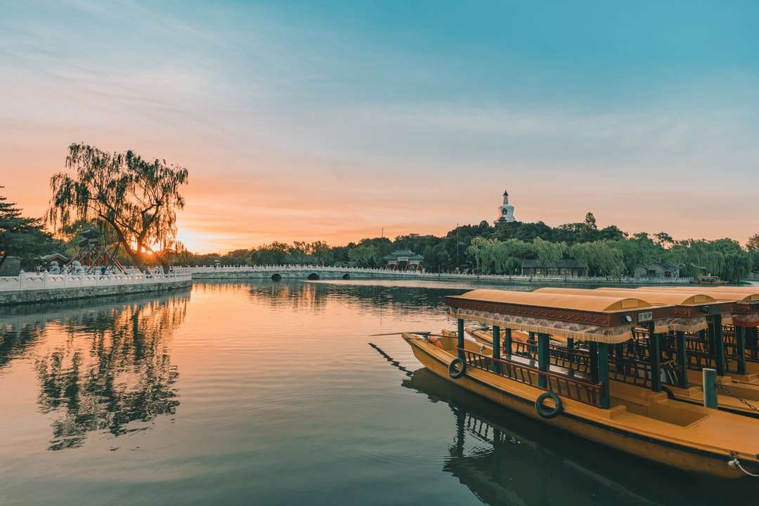 Brown łódź na jeziorze podczas zachodu słońca puzzle online
