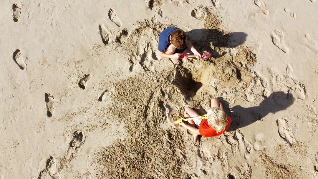 2 chłopców leżących na piasku w ciągu dnia puzzle online