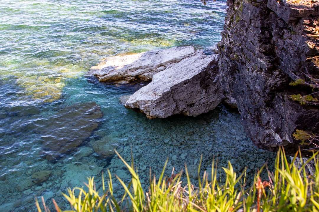 Szara formacja skalna obok ciała wody w ciągu dnia puzzle online