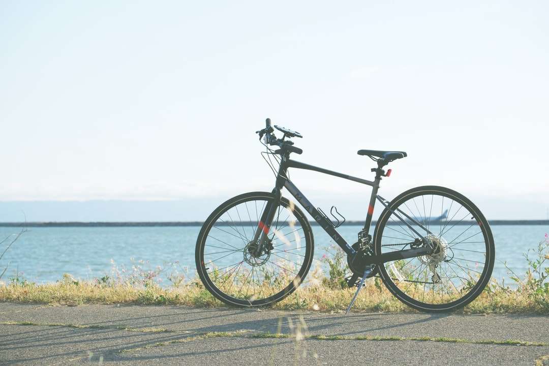 Czarny i szary rower drogowy na szarej betonowej drodze w pobliżu ciała puzzle online
