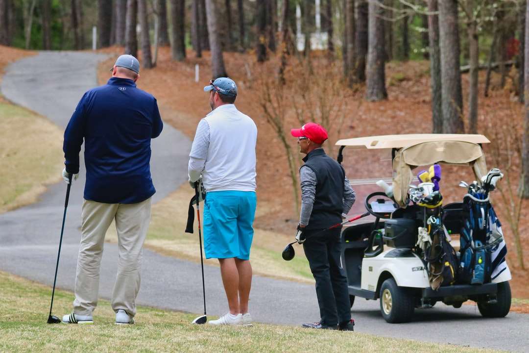 3 mężczyzn w białym mundurze jazda wózek golfowy w ciągu dnia puzzle online