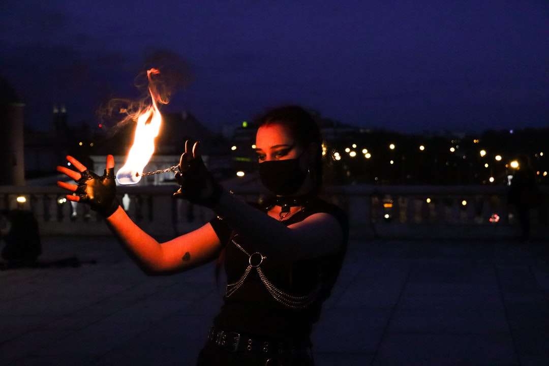 kobieta w czarnej koszuli z długim rękawem trzymająca ogień puzzle online