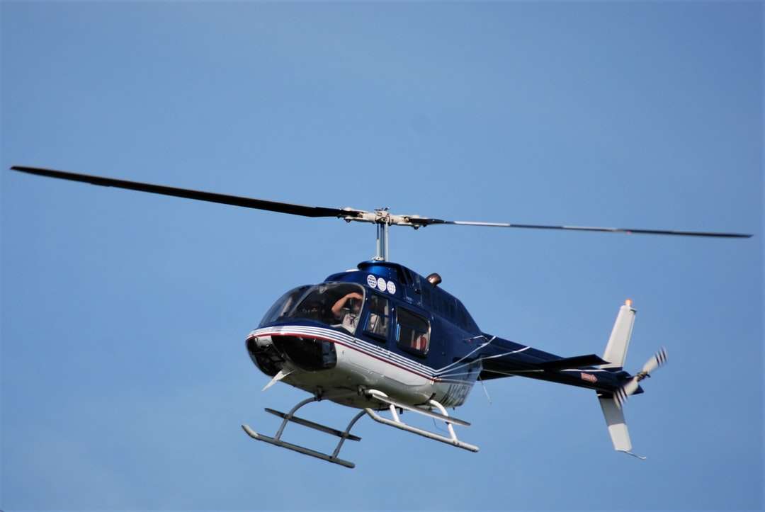 Niebieski i biały helikopter latający na niebie w ciągu dnia puzzle online