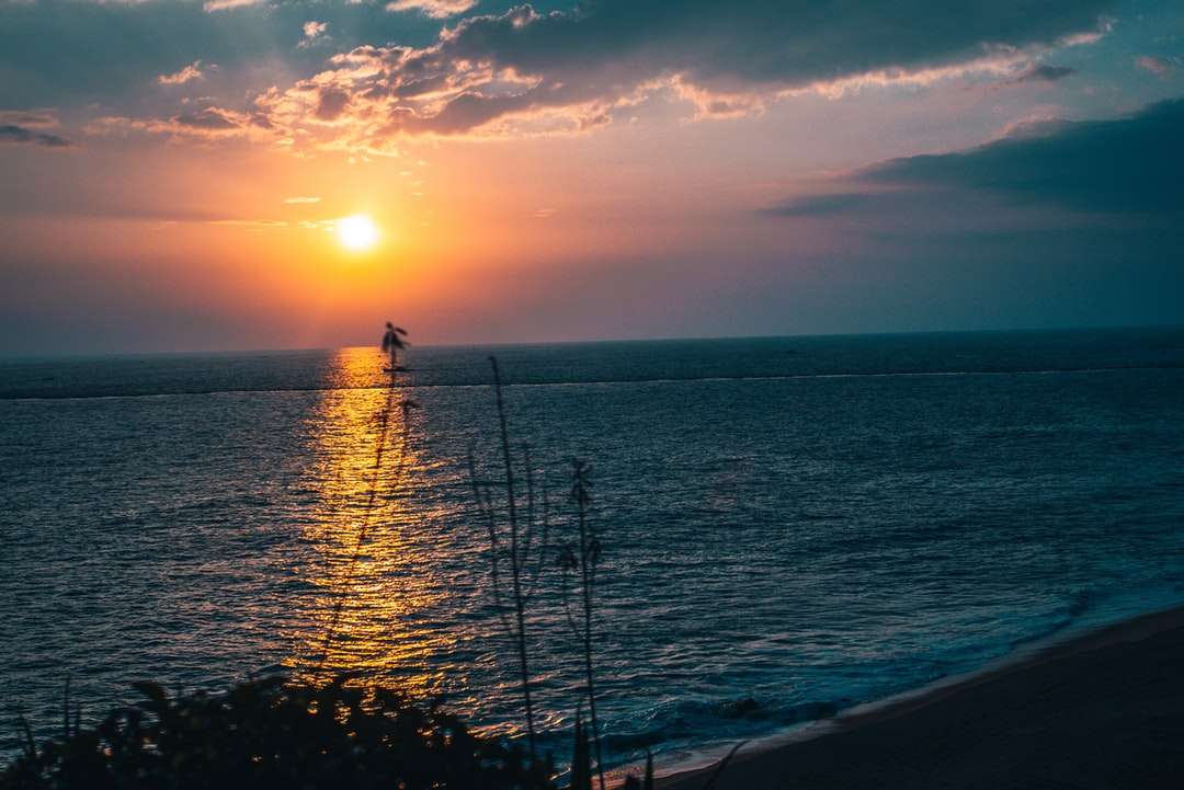 Sylwetka 2 osób stojących na plaży podczas zachodu słońca puzzle online