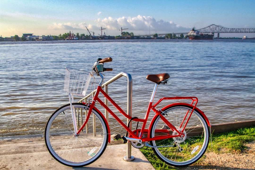 Czerwony rower miasta w pobliżu ciała wody w ciągu dnia puzzle online