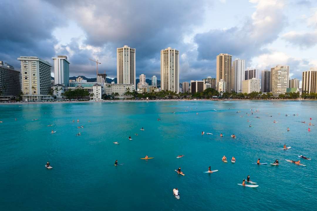 Ludzie pływają na plaży w pobliżu budynków wysokich wzrostów puzzle online