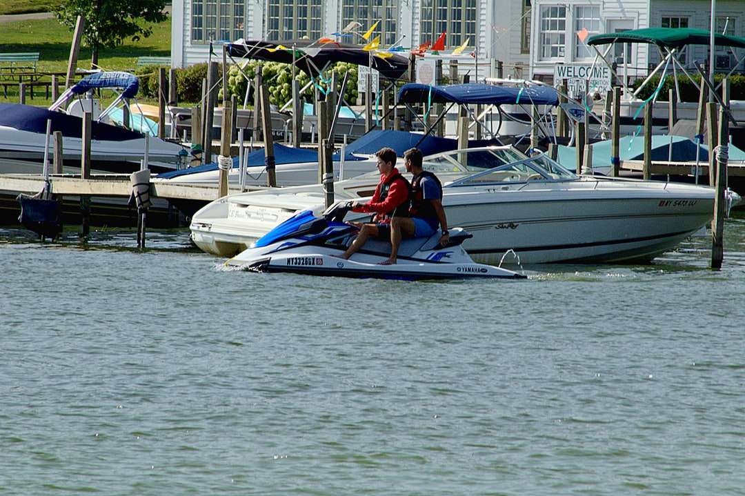 Człowiek w czerwonej koszuli jazda na białej i niebieskiej łodzi puzzle online
