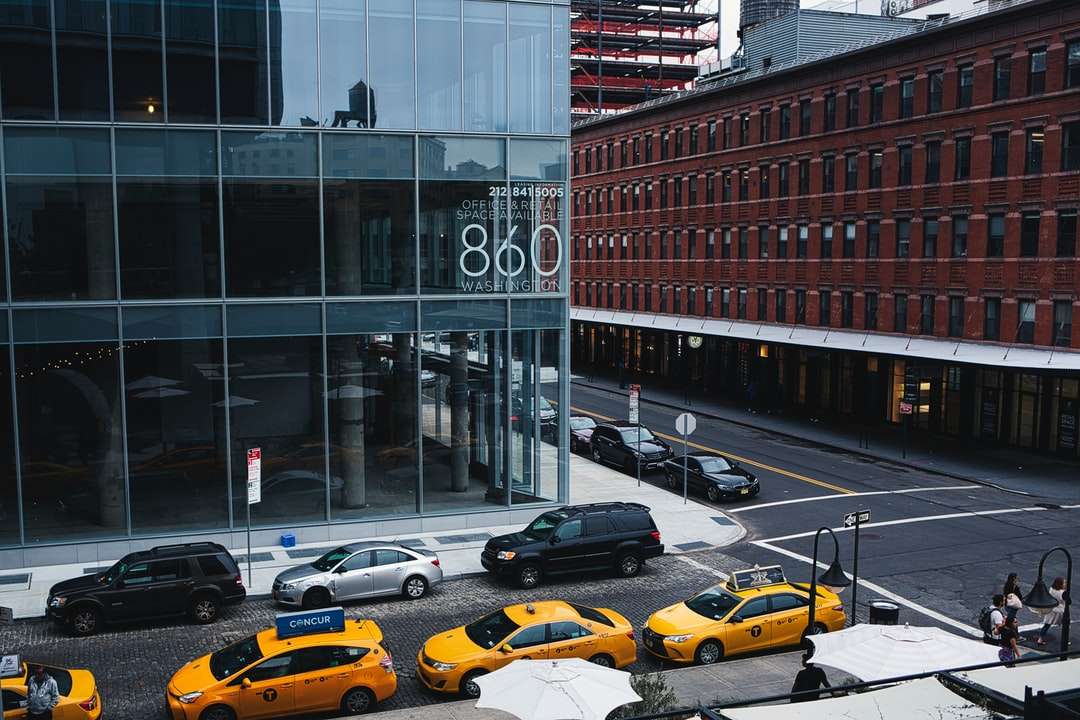 Samochody zaparkowane przed brązowym budynkiem w ciągu dnia puzzle online