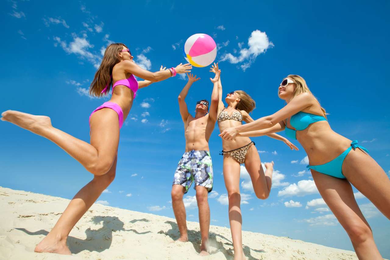 Młodzi ludzie bawić się piłkę na plaży puzzle online