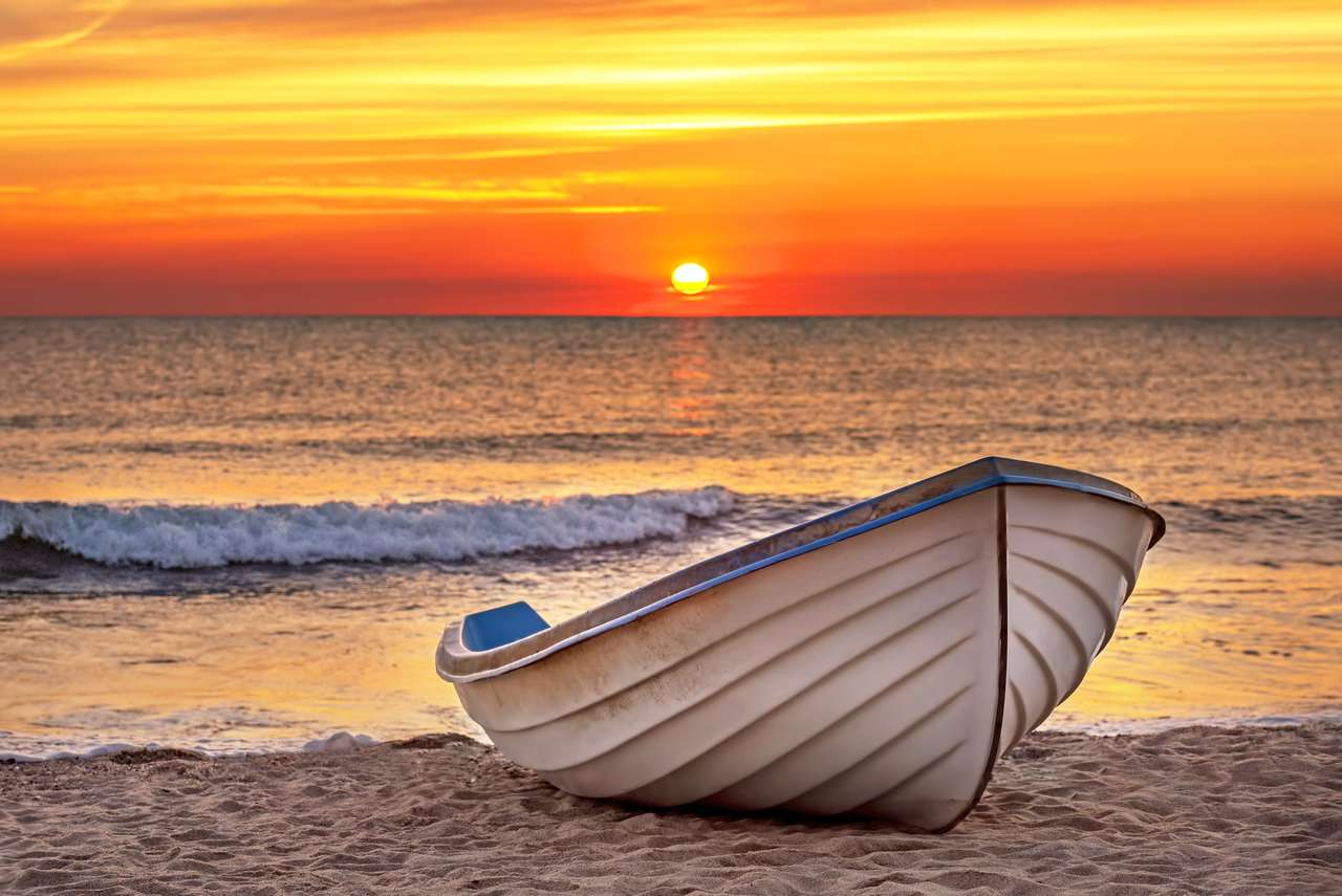 Łódź rybacka na plaży przy wschodem słońca puzzle online