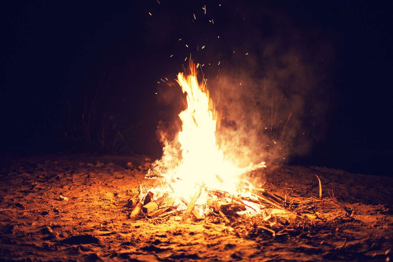 Jasny duży ognisko płonie na plaży w nocy puzzle online