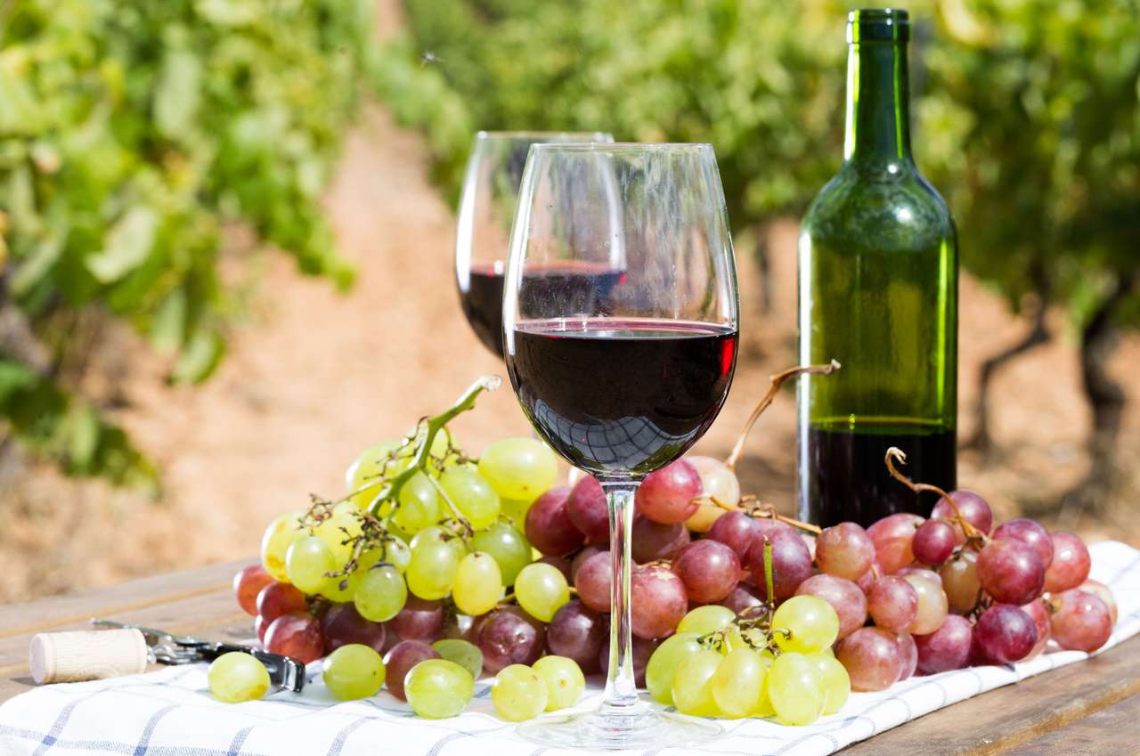 Kieliszek czerwonego wina i dojrzałe winogrona na stole puzzle online