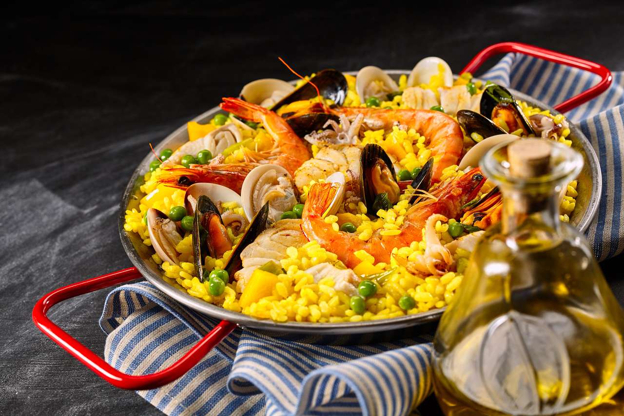 Tradycyjny hiszpański przepis na Paella a la Margarita z różowymi krewetkami, małżami i małżami na żółtym ryżu szafranowym z groszkiem podawanym z oliwą z oliwek na smaczne zakąska owoce morza puzzle online